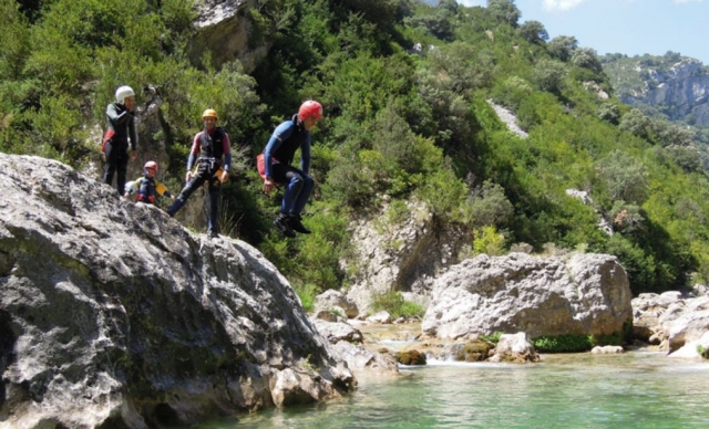 chico saltando al agua desde una roca